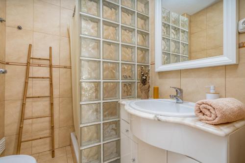 a bathroom with a sink and a glass block wall at Casa Quintião in Ferragudo