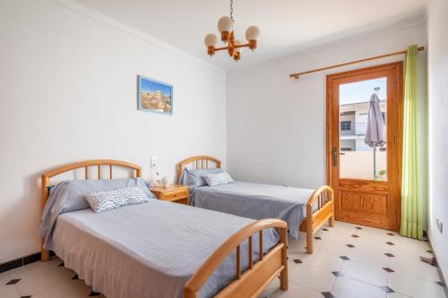 a bedroom with two beds and a window at Cas Cover in Santa Margalida