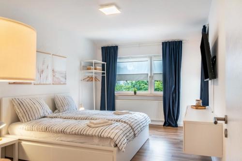 a bedroom with a bed with blue curtains and a window at Fewokuh in Wilhelmshaven