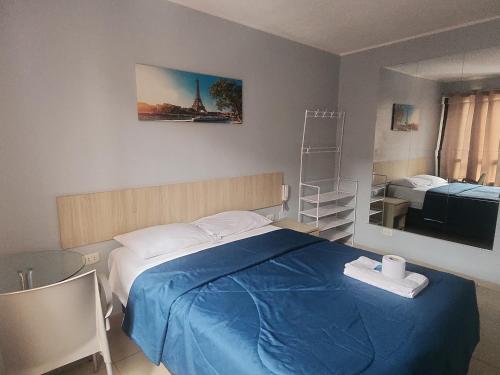 a bedroom with a bed with a blue blanket at Hospedaje costa pacífico in Chimbote
