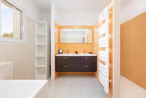 a bathroom with a sink and a bath tub at Villa Lumière Ychoux in Ychoux