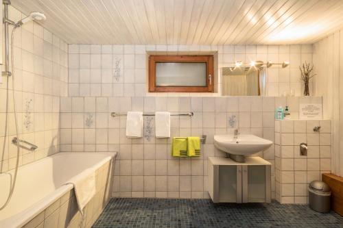a bathroom with a bath tub and a sink at Ferienwohnung im alten Forsthaus in Bermatingen