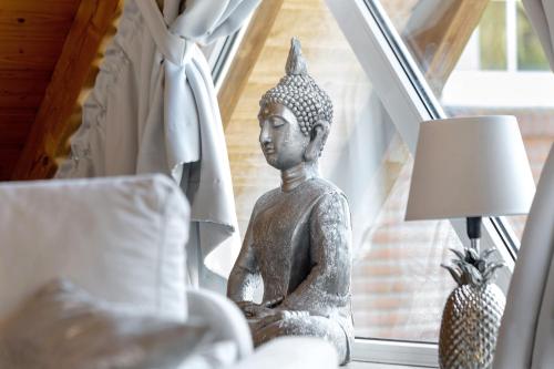 a statue sitting on a window sill next to a lamp at Ferienhaus Harmonie in Südbrookmerland