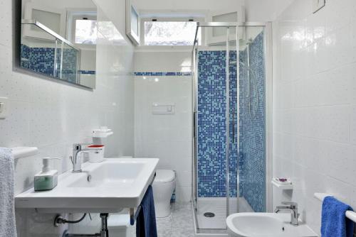 a white bathroom with a sink and a shower at Casa Vacanze Osala in Orosei