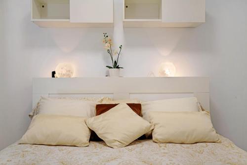 a white bedroom with a bed with pillows at Isla Lobos in Playa Blanca