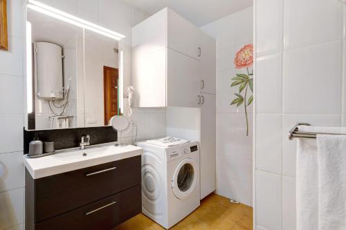 a bathroom with a washing machine and a sink at Isla and Ocean with pool and wifi in Costa Teguise