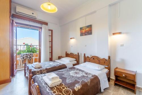 a bedroom with two beds and a balcony at Mires House Side First Floor 10 in Agios Gordios