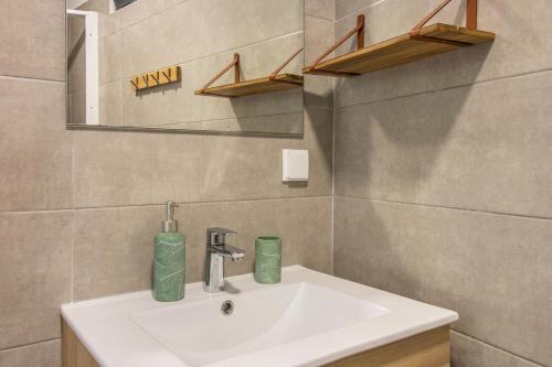 a bathroom with a white sink and a mirror at Palmeira House - Fernandes Cottage in Ponta Delgada