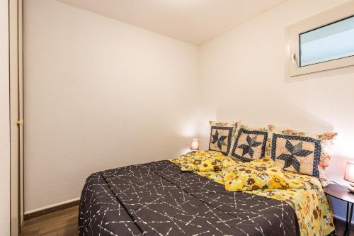 a bedroom with a bed with yellow and black sheets at 2 pièces face océan, Lacanau in Lacanau