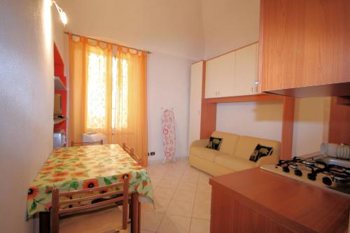een keuken en een woonkamer met een tafel en een bank bij Monolocale GARIBALDI in Loano
