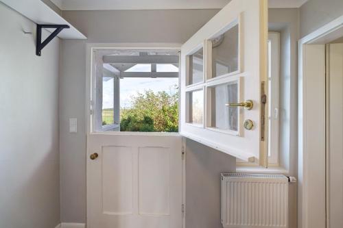 eine weiße Tür in einem Zimmer mit einem Fenster in der Unterkunft Witthus in Pellworm