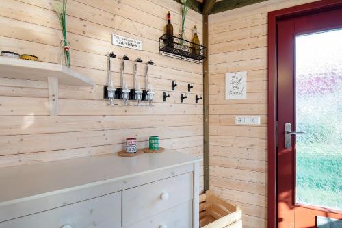 a kitchen with wooden walls and a counter with wine bottles at Ferienhäuser Hainichhöhe in Hörselberg-Hainich