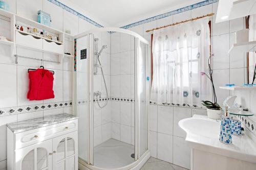 a white bathroom with a shower and a sink at Villa Petite Paradise in Las Lagunas
