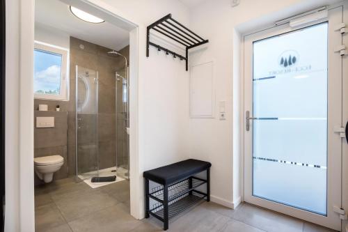 a bathroom with a shower and a stool next to a toilet at Egge Resort 7b mit Whirpool u Sauna in Altenbeken