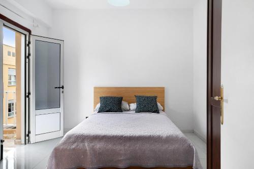 a bedroom with a large bed with blue pillows at Piso Leon y Castillo B in Arrecife