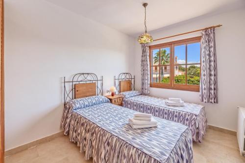 a bedroom with two beds and a window at Villa Isabel in Campos