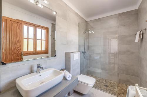 a white bathroom with a sink and a toilet at Villa Isabel in Campos