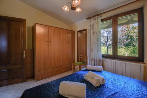 a bedroom with a blue bed and a large window at Casa Lilliu in Villacidro