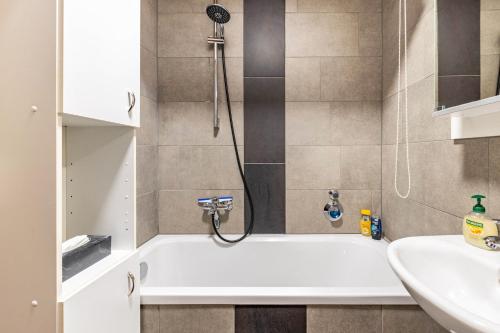 a bathroom with a bath tub and a sink at Ferienwohnung Fernblick in Pottenstein