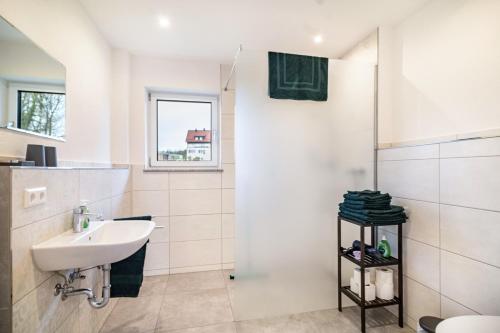 a white bathroom with a sink and a shower at Fichte in Ravensburg