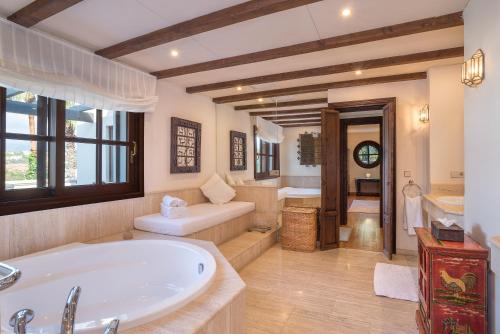 a large bathroom with a tub and a sink at Villa Sildavia in Estepona