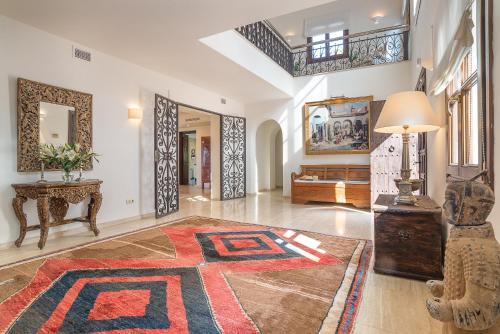 a large living room with a table and a rug at Villa Sildavia in Estepona