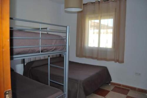 a bedroom with a bunk bed and a window at Chalet Tu Limonero in Chiclana de la Frontera