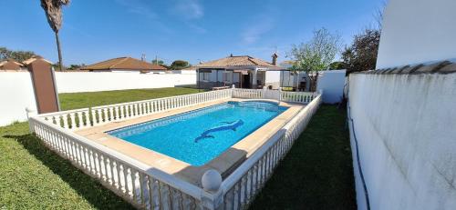a swimming pool with a dolphin in the water at Chalet Tu Limonero in Chiclana de la Frontera