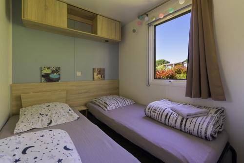 a bedroom with two beds and a window at Mobilhome 373 in Lattes