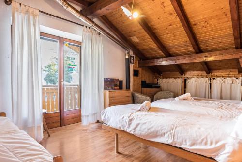 a bedroom with two beds and a wooden ceiling at The Lodge Monte Bondone in Vason