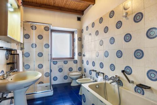a bathroom with two toilets and a sink and a tub at The Lodge Monte Bondone in Vason