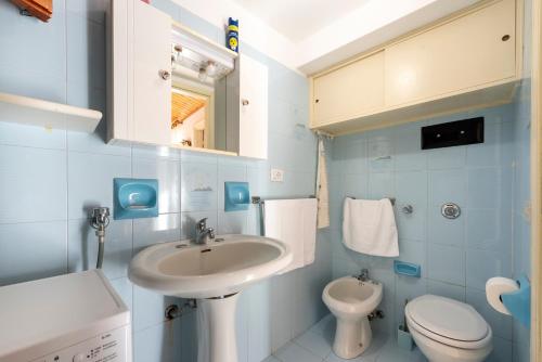 a blue bathroom with a sink and a toilet at La Casetta Della Rocca Cefalù in Cefalù