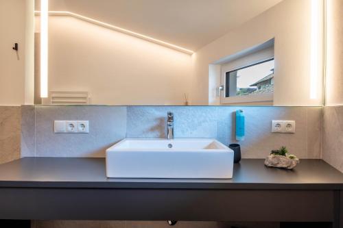 a bathroom with a sink and a mirror at Luisl Hof - Apartment Pomum in Cornaiano