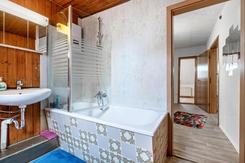 a bathroom with a tub and a sink at Haus Elseaue in Bünde