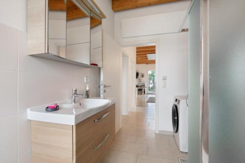 a bathroom with a sink and a washing machine at Ferienwohnung Panoramablick in Leipheim
