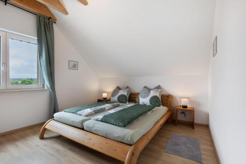 a bedroom with a wooden bed with a large window at Ferienwohnung Panoramablick in Leipheim