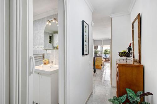a white bathroom with a sink and a mirror at Apartamento Mertxe in Arona