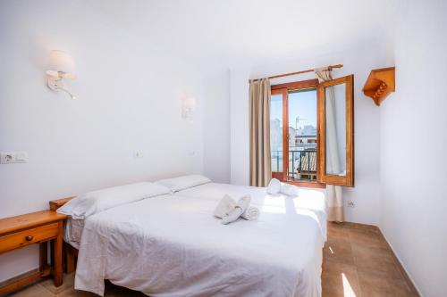 a bedroom with two beds and a window at Sa Torre iii in Canyamel