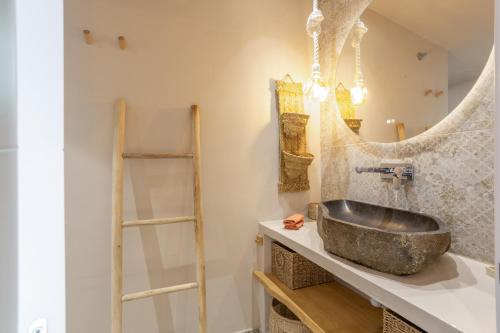 a bathroom with a stone sink and a mirror at Oceania Villa Private Pool Garden in Chayofa