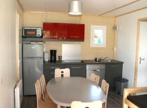 a small kitchen with a table and a refrigerator at Chalet 35m2 3 chambres in Sciez