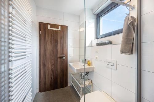 a bathroom with a toilet and a sink and a window at Ferienhaus Sonnenwind Hainer See Og in Neukieritzsch
