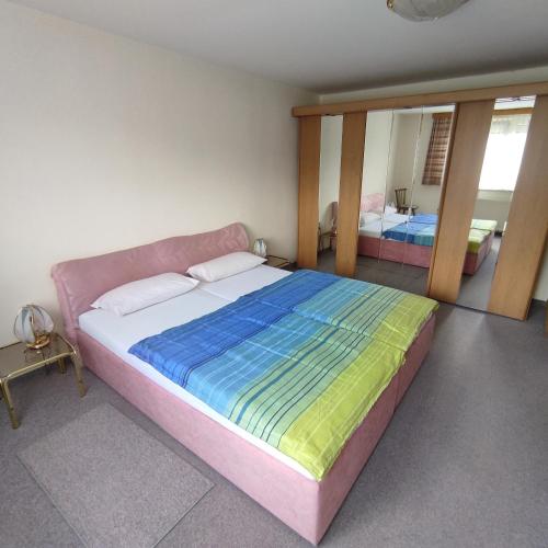 a bedroom with a large bed and a mirror at Haus Maria Bodensdorf in Tratten