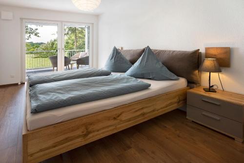 a bed with blue pillows on it in a room at Ferienwohnung Donautal in Meßkirch