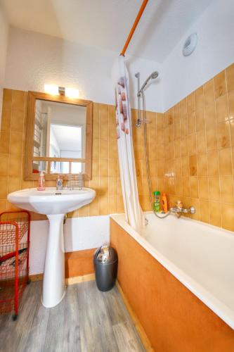 een badkamer met een wastafel en een badkuip en een wastafel bij Comte Rouge in Taninges