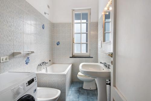 a white bathroom with a sink and a tub and a toilet at Via Colombo 12 Bilo in Bonassola
