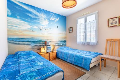 a bedroom with two beds and a painting of the ocean at Maison Salorge - piscine privée in Jard-sur-Mer