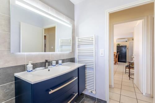 a bathroom with a sink and a mirror at Maison Salorge - piscine privée in Jard-sur-Mer
