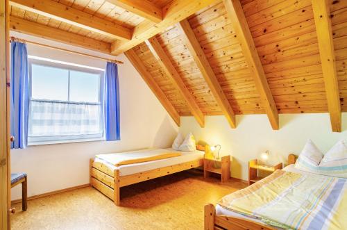 a bedroom with two beds and a window at Beutenmühle Straussenfarm Dach in Owingen