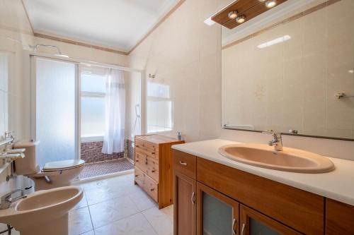 a bathroom with a sink and a toilet and a mirror at Villa Juana Maria in Cala Murada