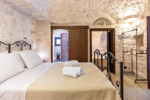 a bedroom with a bed with two towels on it at I Trulli di Dona Filomena in Selva di Fasano